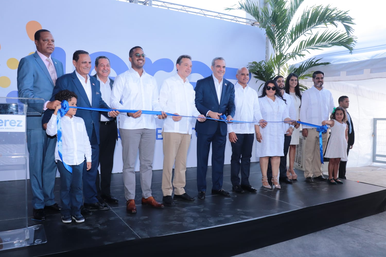 Con la presencia del presidente de la República, Luis Abinader, fue inaugurado este jueves el almacén de provisiones Jerez Gran Abasto, ubicado en el kilómetro 8 ½ de la carretera Sánchez, en el Distrito Nacional. En este establecimiento los usuarios tendrán acceso en un solo lugar a comprar al por mayor y al detalle alimentos y artículos de primera necesidad, por lo que negocios, intermediarios y familias dominicanas podrán beneficiarse, resaltó Jorge Jerez, presidente del Grupo Jerez. Con la inauguración del nuevo establecimiento se generan 350 empleos directos y 150 indirectos, para un total de 500 nuevos empleos. Al hablar durante la inauguración, Jerez sostuvo que los jóvenes representan más del 60 % de los nuevos empleos del establecimiento y que fueron seleccionados para su primer empleo, ya que entiende, hay que darle oportunidades a ese sector. Manifestó también el compromiso de su familia y Casa Hermanos Jerez con la sociedad dominicana. “Estamos mejorando en todos los renglones, hoy tenemos una justicia que podemos confiar mucho más en ella, tenemos instituciones que nos resuelven mucho más rápido cualquier dificultad, tenemos con quien hablar”, agregó Jerez, al destacar las acciones del gobierno en beneficio del sector comercial. Destacó además que en la actualidad algunos precios de la canasta básica han estado bajando, ya que el país ha tenido un manejo excelente de la crisis mundial. “Gracias a Dios y a la buena gestión gubernamental, el país ha tenido un manejo excelente lo cual ha permitido que se mantenga un buen ritmo de crecimiento que por ende se manifiesta en nuestras actividades comerciales, con un aumento de las ventas”, dijo. Asistentes Al acto también asistió el ministro de Industria, Comercio y Mipymes, Víctor -Ito- Bisonó; el ministro de la Juventud, Rafael Feliz García; el viceministro de Fomento a las Mipymes, Jorge Morales, entre otras autoridades y representantes del sector comercio. Casa Hermanos Jerez Jerez Gran Abasto es parte de Casa Hermanos Jerez, la cual fue fundada por los comerciantes Jorge Jerez y Shirley Atabeira Reynoso Gil. Jorge Jerez comenzó con un colmado en el 1989 y en el año 1991 abrió su primer almacén, lo que al día de hoy es Casa Hermanos Jerez. De ahí, se ha ido desarrollando en representación de marcas, importaciones, y comercio en general. Casa Hermanos Jerez comenzó a funcionar en el año 1992 en el sector 30 de Mayo. Eventualmente, el negocio se mudó al sector Miramar, en la Avenida Independencia. En esos tiempos, la pareja de esposos Jorge Jerez y Atabeira Reynoso hacía todos los procesos: recibir y vender la mercancía, además de toda la contabilidad necesaria. Eventualmente, el negocio fue creciendo y se fue contratando a más personas, algunos de los cuales aún trabajan al día de hoy. Actualmente, Jerez Gran Abasto es la nueva empresa como parte del grupo. El Grupo Jerez se encuentra en un proceso de modernización.